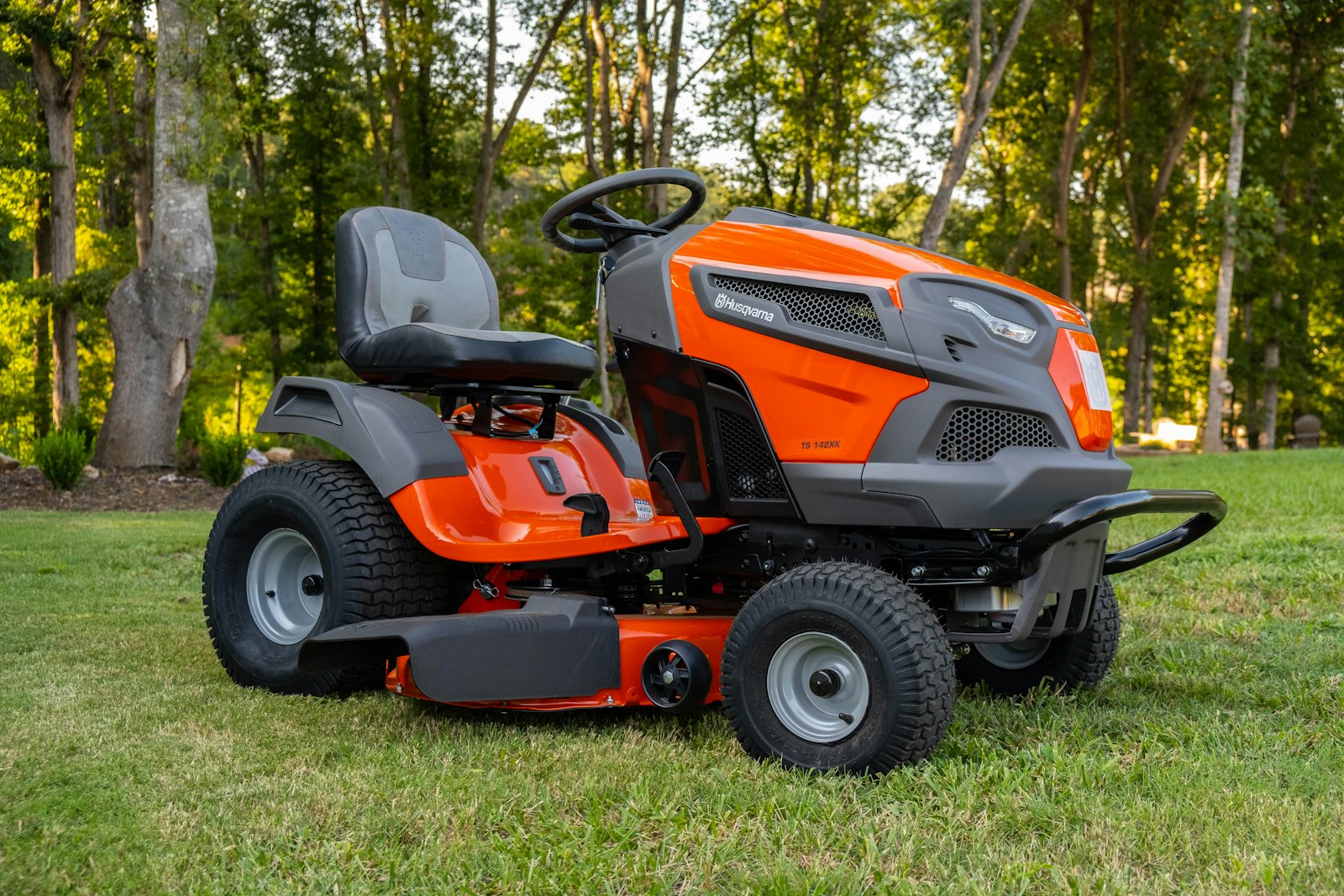 Orange zero-turn mower parked on a cut Bermuda lawn.